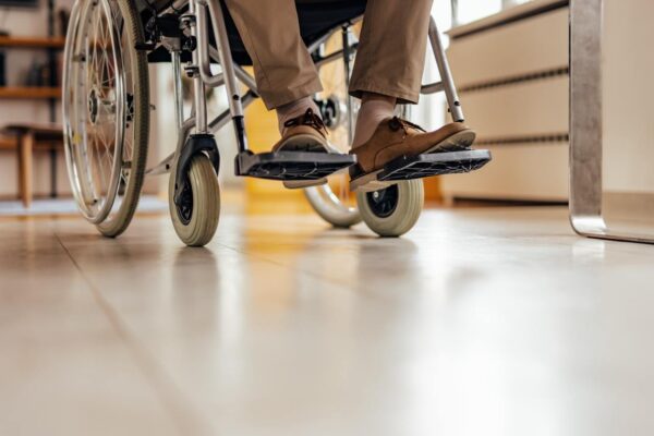 Two feet of a man in a wheelchair