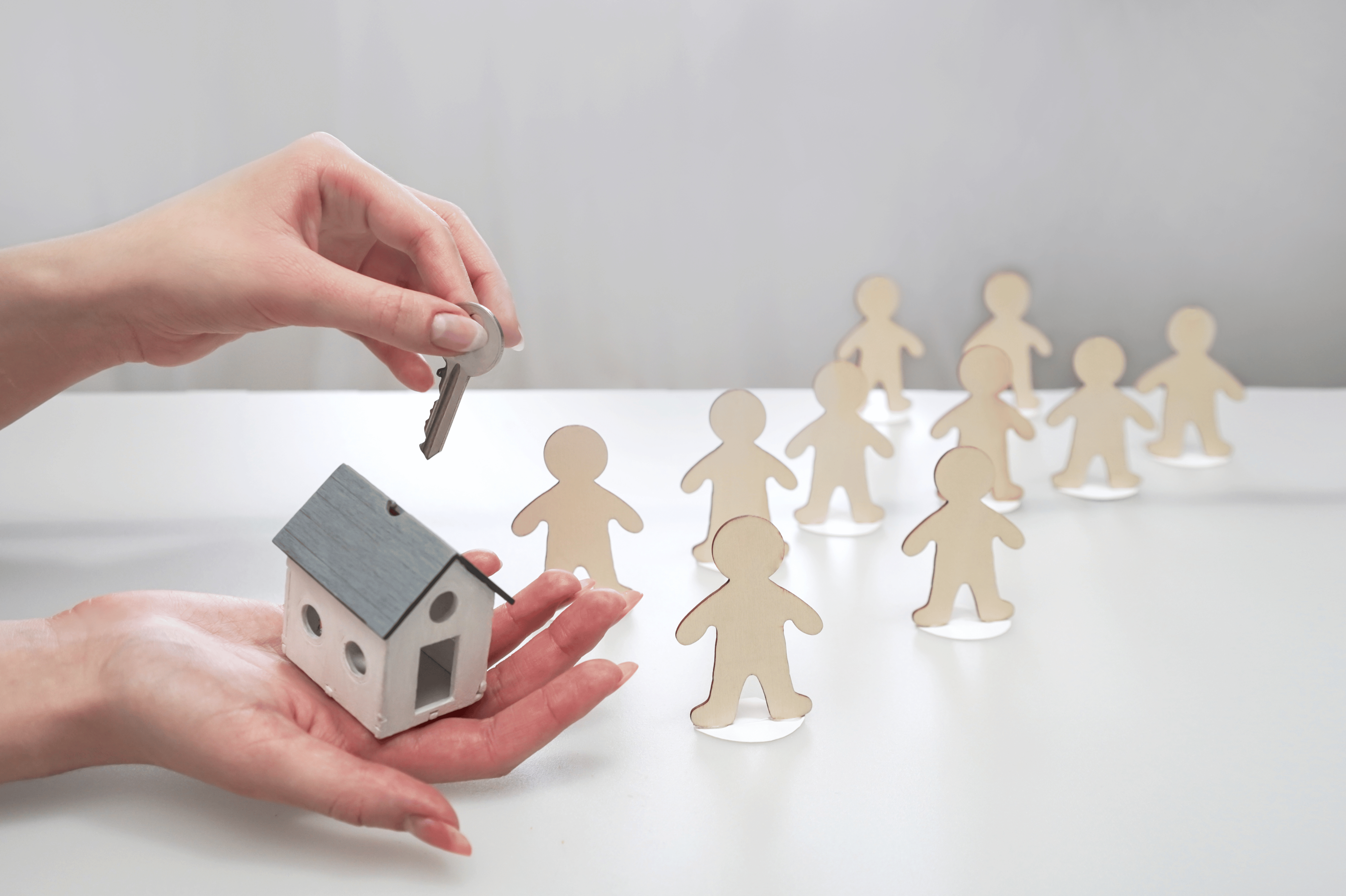 hand holding a model of a house and a key